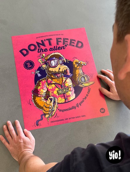 L'illustrateur Yio dans son studio avec l'affiche narrative ALF